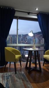 a living room with a table and chairs and a large window at Luxury Apartment, Prime Location, Panoramic Views in La Paz