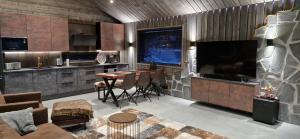 a living room with a table and a large television at Rusty Reindeer Levi in Levi