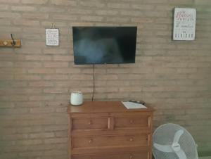 einen Fernseher auf einer hölzernen Kommode in der Unterkunft Portal del Río Posada in Santa Rosa de Calamuchita