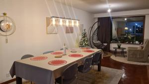 a dining room with a table and a christmas tree at 3-bedroom lake view and near center apartment with sauna in Lahti +25 photos