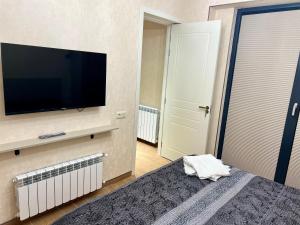 a bedroom with a flat screen tv and a bed at New Gudauri Redco F1 in Gudauri