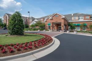 a driveway in front of a building with flowers at Residence Inn Dulles Airport At Dulles 28 Centre in Sterling