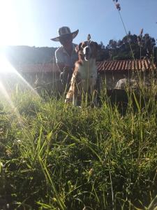 a man with a dog standing in the grass at Casa de campo Namasté in Sutatausa