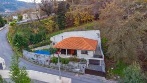 eine Luftansicht eines Hauses mit orangefarbenem Dach in der Unterkunft Casa Oliveira Gêres in Terras de Bouro