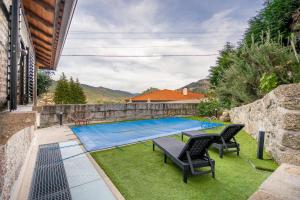 einen Pool im Garten mit zwei Stühlen und einem Tisch in der Unterkunft Casa Oliveira Gêres in Terras de Bouro
