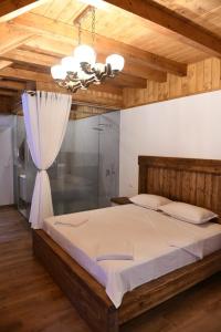 a bedroom with a large bed and a chandelier at Hotel - Resort Vellezerit Doka in Klos