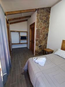 een slaapkamer met een bed en een stenen muur bij Cabañas Los Olivos in Ixmiquilpan +35 foto's