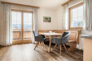 a dining room with a table and chairs and windows at Schartlhof in Flachau