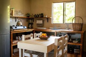 una cucina con un tavolo con una ciotola di frutta sopra di Vogelsang Farm Cottage a Oudtshoorn
