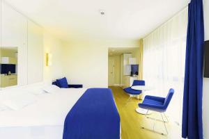 una camera da letto con un letto, due sedie e un tavolo di Elite Class Sea View Aparthotel In Orbi City Batumi a Batumi