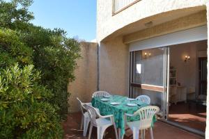 une table et des chaises vertes sur la terrasse dans l'établissement SP620-033 Maison 4 pièces SAINT PIERRE LA MER, à Saint Pierre La Mer