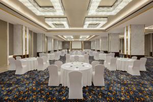ein Festsaal mit weißen Tischen und weißen Stühlen in der Unterkunft Indore Marriott Hotel in Indore + 105 Fotos