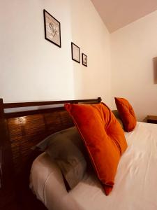 łóżko z pomarańczowymi poduszkami w sypialni w obiekcie Sicilia Vacation rooms w Trapani