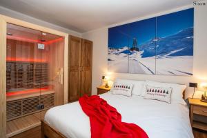 a bedroom with a bed with a red blanket on it at Apartments Les Crouses in Valtournenche