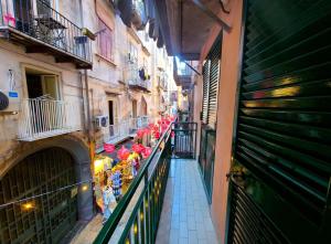 an alley with a bunch of umbrellas on a balcony at la casa di patta a spaccanapoli in Naples