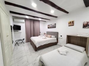 a bedroom with two beds and a television in it at la casa di patta a spaccanapoli in Naples