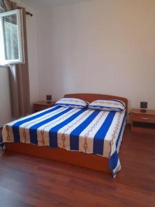 a bedroom with a bed with a blue and white blanket at Apartment near the sea in Šibenik