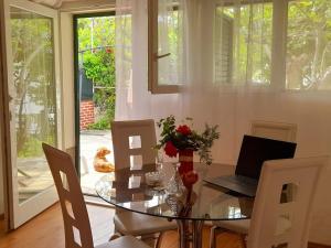 a dining room with a glass table with a laptop on it at Apartment near the sea in Šibenik +13 photos