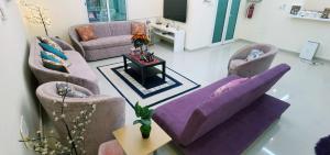 a living room with a purple couch and chairs at إستراحة شاطئ الشمال North Beach Resort in Ar Ruʼays