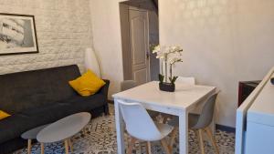 a living room with a couch and a table and chairs at La Ch'tite Cahute in Ambleteuse