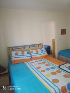 - une chambre avec un lit doté d'un couvre-lit coloré dans l'établissement Tree-lined beach house, à Matinhos