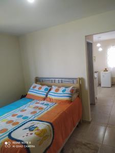 une chambre avec un lit avec une couverture orange dans l'établissement Tree-lined beach house, à Matinhos