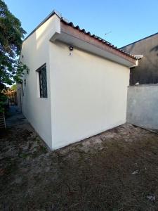 a white building with a red roof at Casa a 2 quadras do mar reformada in Matinhos +6 photos