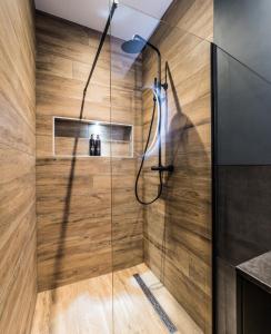 a bathroom with a shower with a wooden wall at Haya Historic - Viognier in The Hague