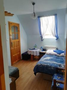 Un dormitorio con dos camas y una mesa y una ventana. en U Maryni, en Szczawnik