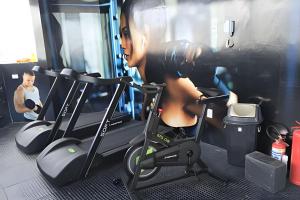 Una donna sul tapis roulant in palestra di Espetacular Flat em Miramar a João Pessoa