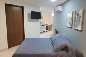 a bedroom with a bed and a flat screen tv at Espetacular Flat em Miramar in João Pessoa