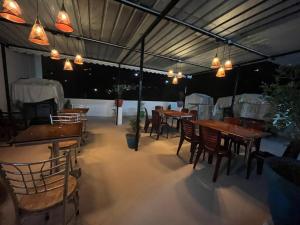 a restaurant with wooden tables and chairs and lights at BanyanThree in Kodaikānāl