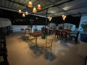a dining room with tables and chairs and lights at BanyanThree in Kodaikānāl