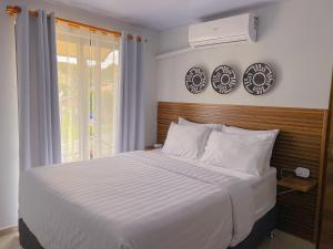 a bedroom with a large white bed and a window at Monstera Apartments Monteverde in Monteverde Costa Rica
