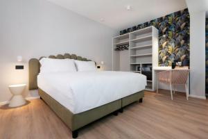 维罗纳Dimora La Fratta的卧室里有一张白色的大床和一张书桌