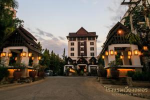 a building with a clock tower in the middle of a street at Wienglakor Hotel Lampang in Lampang