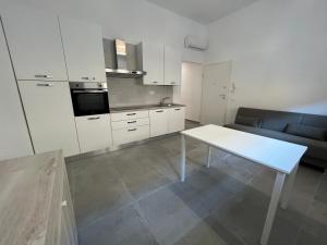 a kitchen with a white table and a couch at Fiume 21 apartment -7- Venturina Terme in Venturina Terme