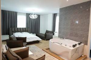 a bathroom with a bath tub and a bedroom with a bed at Kashar Hotel 3A in Tirana