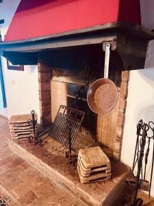 マッサ・マリッティマにあるAgriturismo Podere Acquarelloの鍋とフライパンが置かれたレンガ造りの暖炉