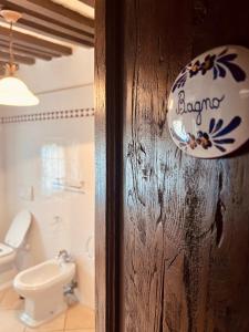 マッサ・マリッティマにあるAgriturismo Podere Acquarelloのバスルームへのドア(トイレ、照明付)