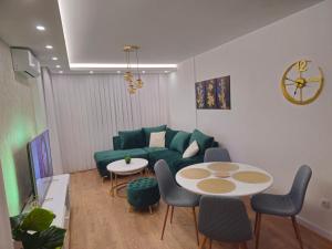 a living room with a green couch and a table at Apartman Dora in Doboj