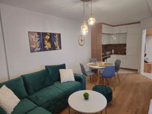 a living room with a green couch and a table at Apartman Dora in Doboj