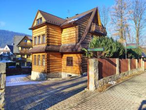 扎科帕内Kowali Wierch的街道上的木房子,带围栏