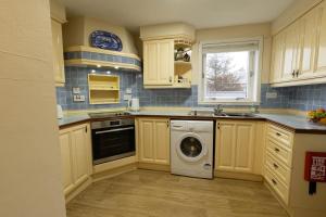 a kitchen with a washer and a washing machine at Stouts Court Apartment in Lerwick