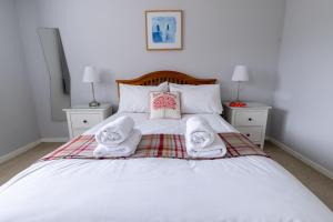 a bedroom with a bed with towels on it at Stouts Court Apartment in Lerwick