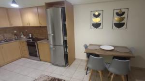 a kitchen with a table and a stainless steel refrigerator at La casa bella di Chalkida 2 in Chalkida