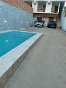 een zwembad op een parkeerplaats naast een gebouw bij Pousada Caribe Milagrense II in São Miguel dos Milagres