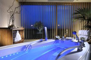a bathroom with a blue tub with a large window at Rome Marriott Park Hotel in Rome
