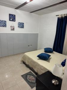 a bedroom with a bed with blue pillows on it at Acogedor Aparta estudio central in Popayan