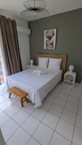 a bedroom with a bed and a bench in it at Le Nid Urbain in Fort-de-France